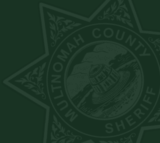 Muted MCSO logo against dark green background.