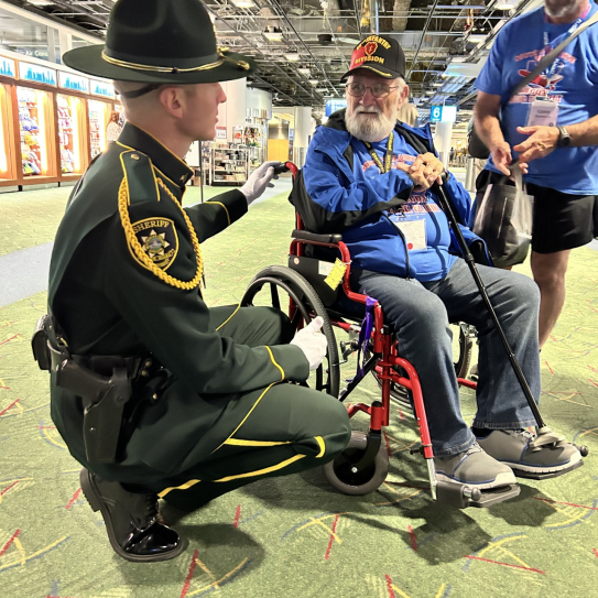 MCSO Sgt. Bryan White visits with a U.S. veteran returning home from the fall Honor Flight to Washington, D.C.