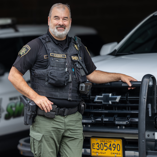 Deputy Kaiser stands next to his patrol vehicle at the Troutdale Sheriff's Operation Center. 