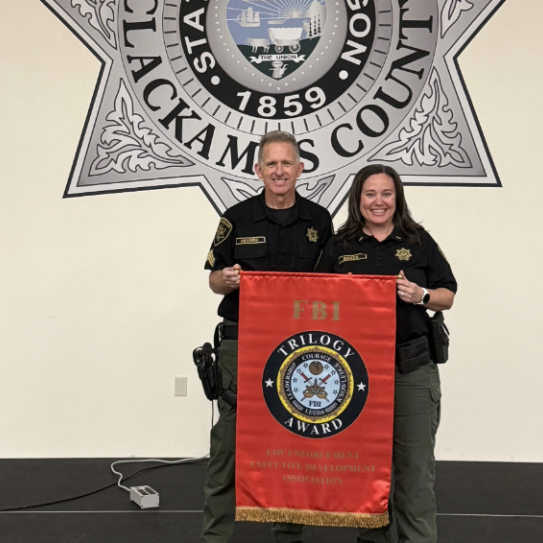 Sgt. Hevern (left) and Lt. Baker (right) hold up an FBI LEEDA Award banner