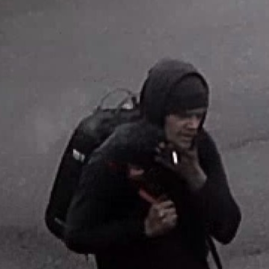 Suspected thief wearing all black with a hood and a backpack