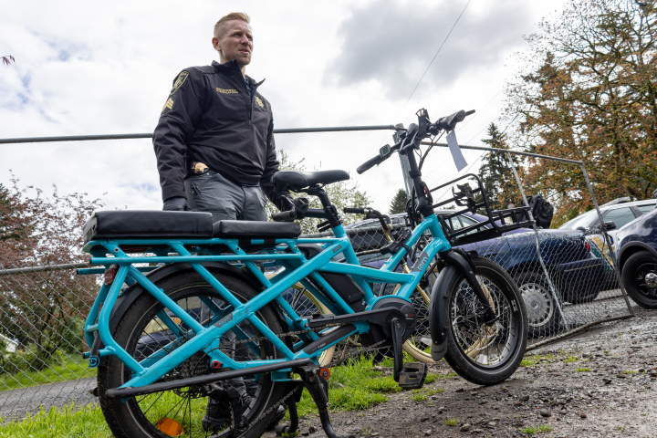 A sergeant with the Multnomah County Sheriff’s Office looks over a stolen bike recovered during a search warrant. 