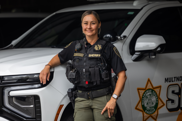 Captain Jennifer Ciobanasiu poses next to a patrol vehicle.