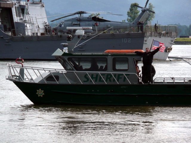 Lt. Lichatowich stands on a River Patrol Unit vessel as his team escorts a U.S. Navy Vessel to the Portland waterfront for Fleet Week.