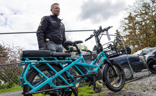 A sergeant with the Multnomah County Sheriff’s Office looks over a stolen bike recovered during a search warrant. 