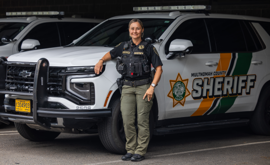 Captain Jennifer Ciobanasiu poses next to a patrol vehicle
