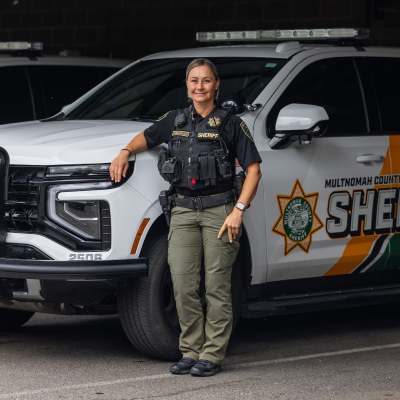 Captain Jennifer Ciobanasiu poses next to a patrol vehicle